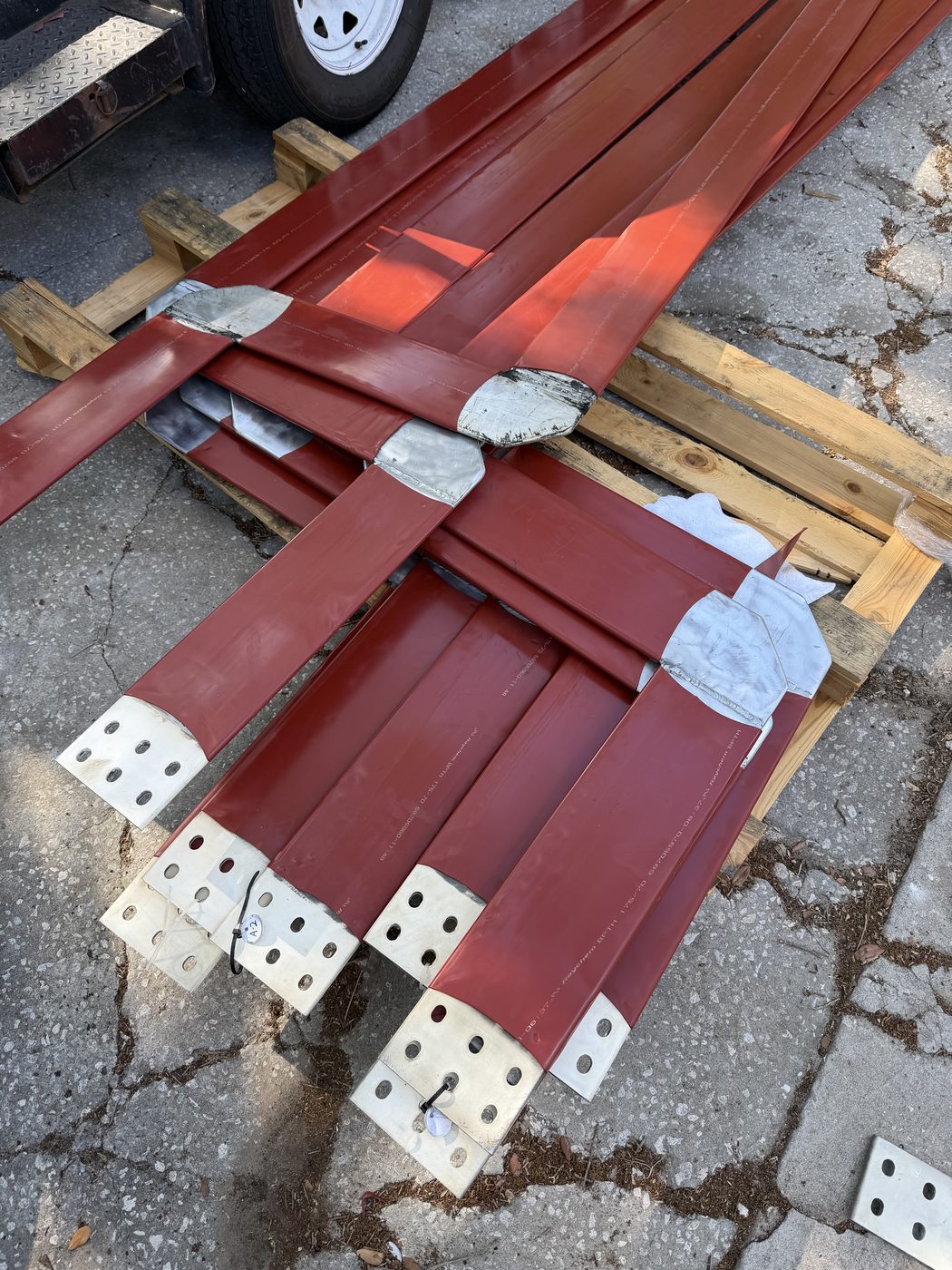 Refurbished 13.8 kV generator bus bar sections on pallet, new Raychem insulation installed and ends silver-plated, ready for transport back to the plant.