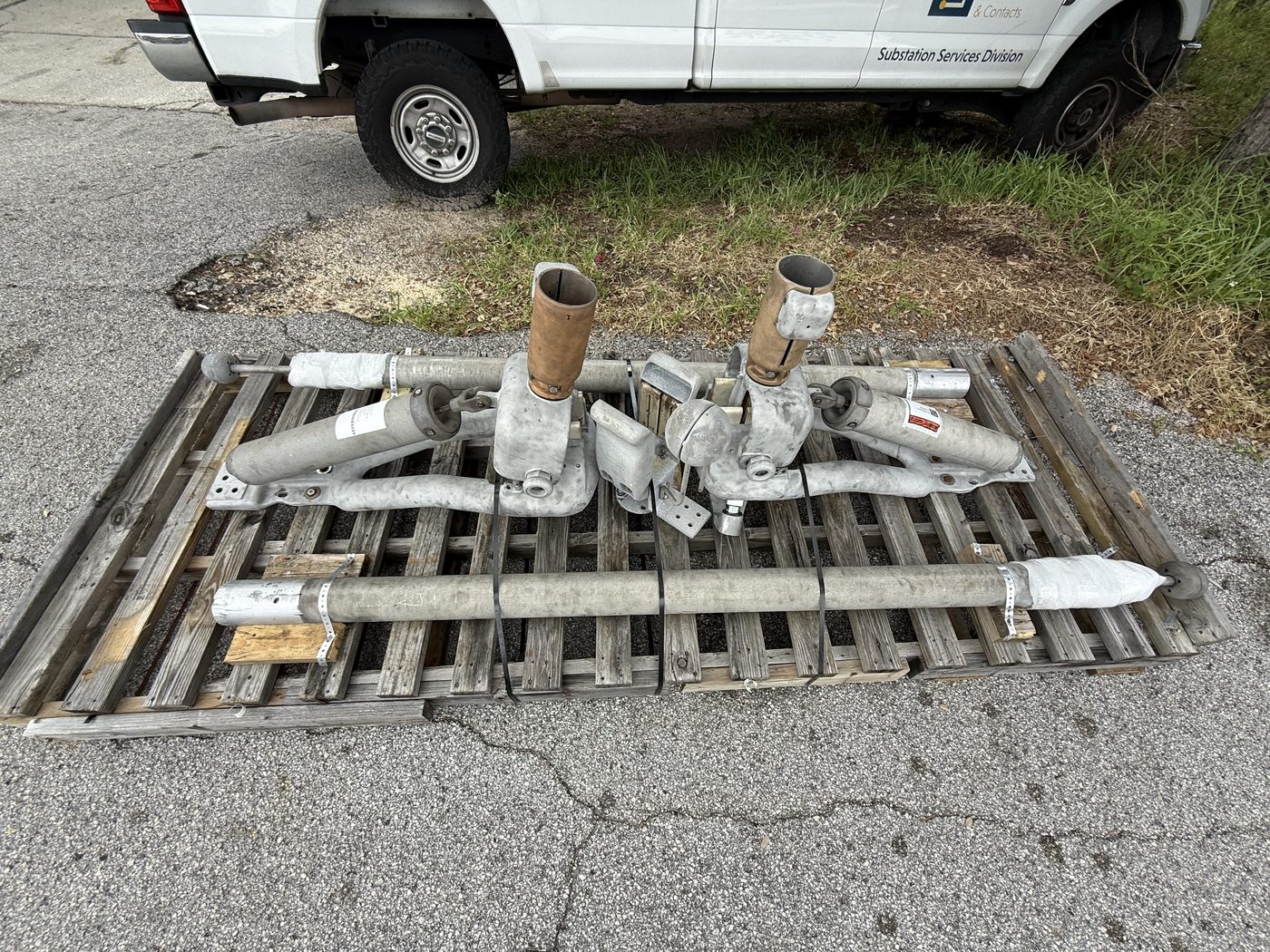 Two Southern States EV1 disconnect switches on a pallet at Southern Switch, the unit on the right has a new machined arm, visibly brighter aluminum compared to the original.