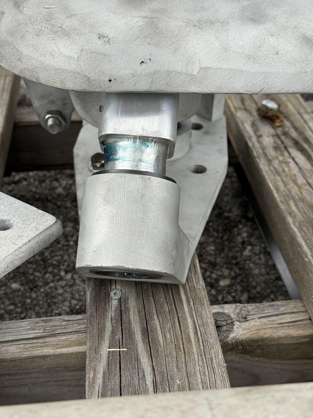Close-up of the pivot and bushing connection between the new machined arm and the original Southern States EV1 cast housing, fit surfaces visible.
