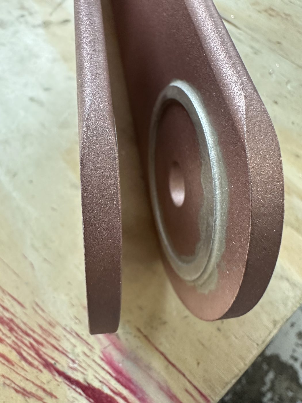 Close-up of the silver ring insert at the blade pivot point on the refurbished utility disconnect switch, machined silver contact visible at the blade tip boss.