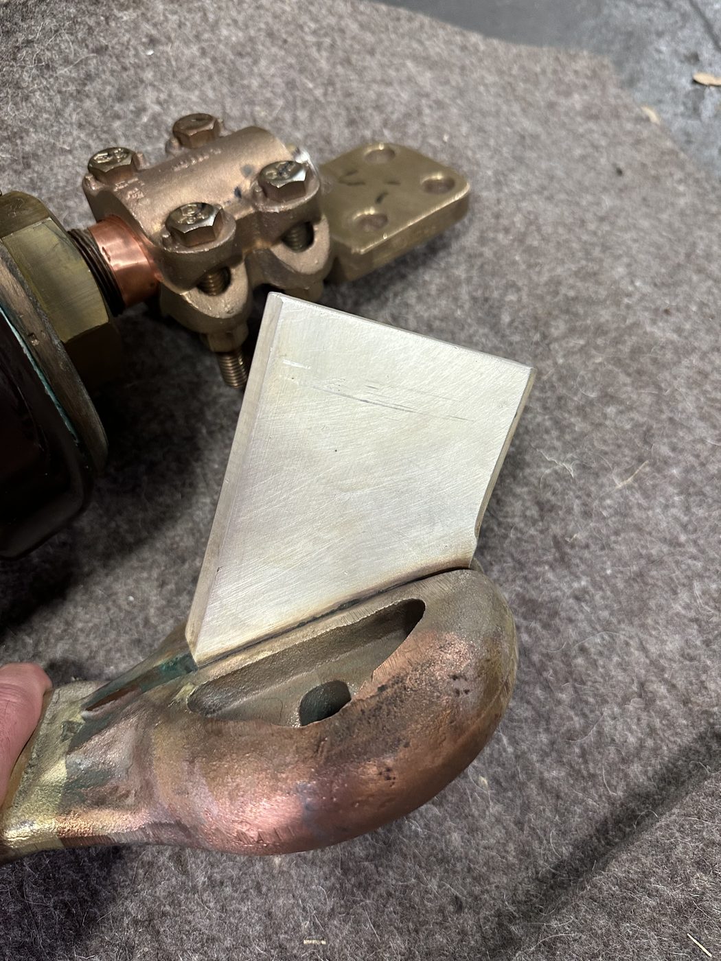 Machined silver insert plate on the stationary contact face of a refurbished utility distribution disconnect switch, bright silver contact surface on copper and brass assembly.