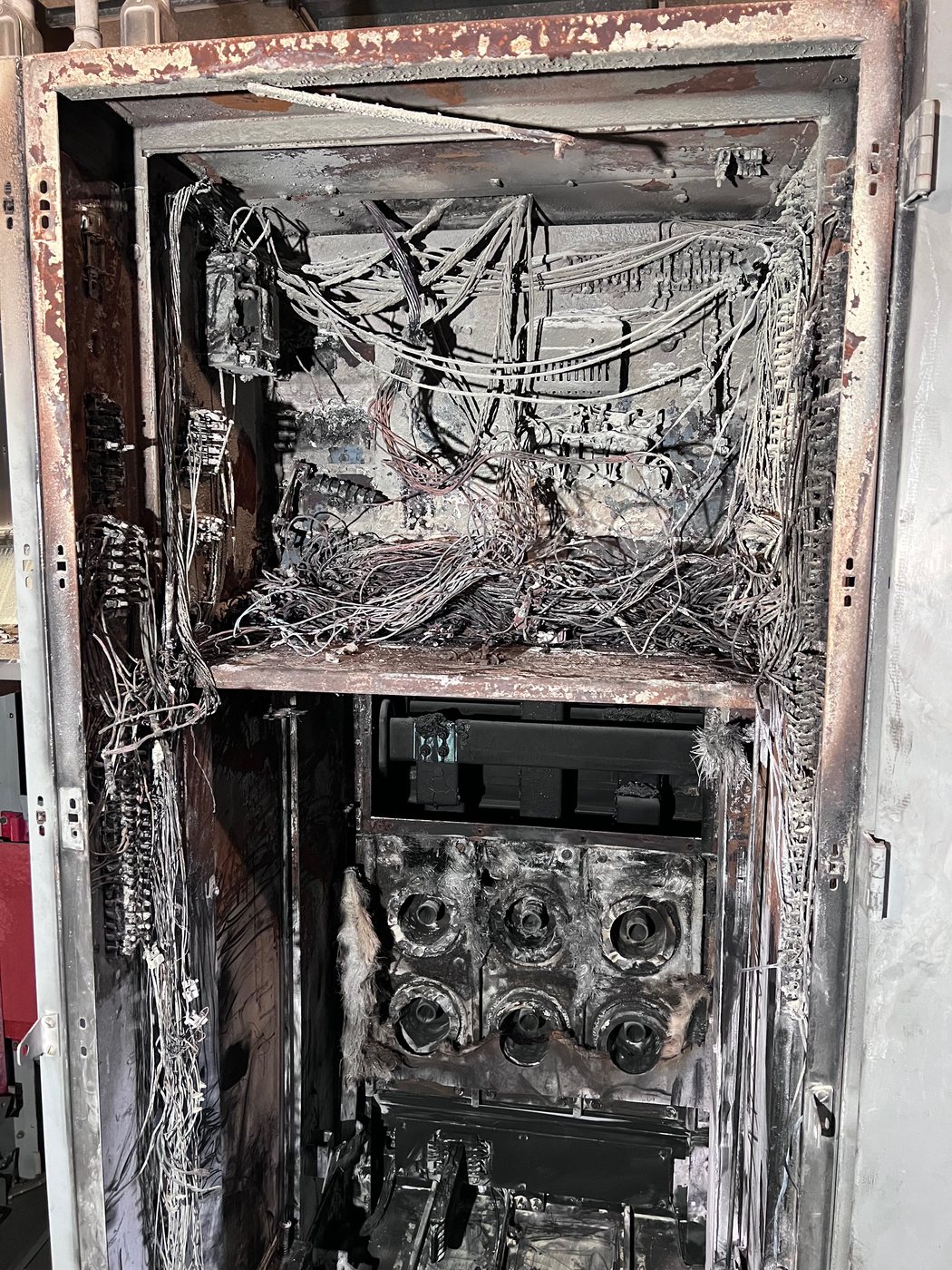 Fire and fault damage inside a breaker cubicle at Duke Energy's Crystal River plant, charred insulation and scorched cabinet interior.