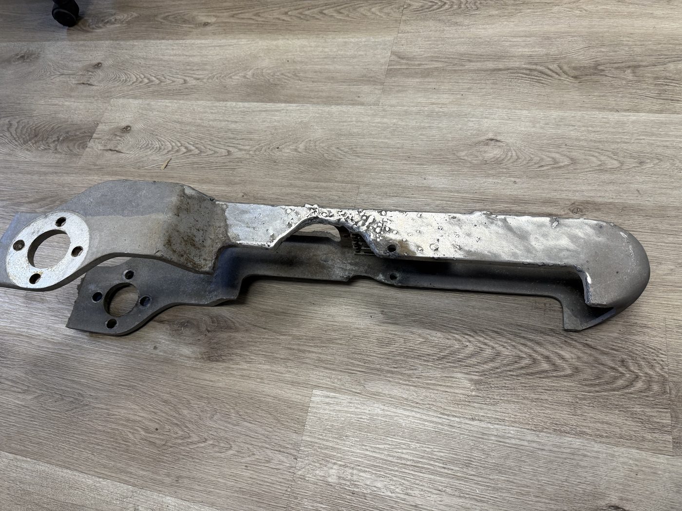 Original 500 kV pantograph switch jaw after lightning strike, aluminum nearly burned through with severe pitting and heat damage across the blade and contact area.