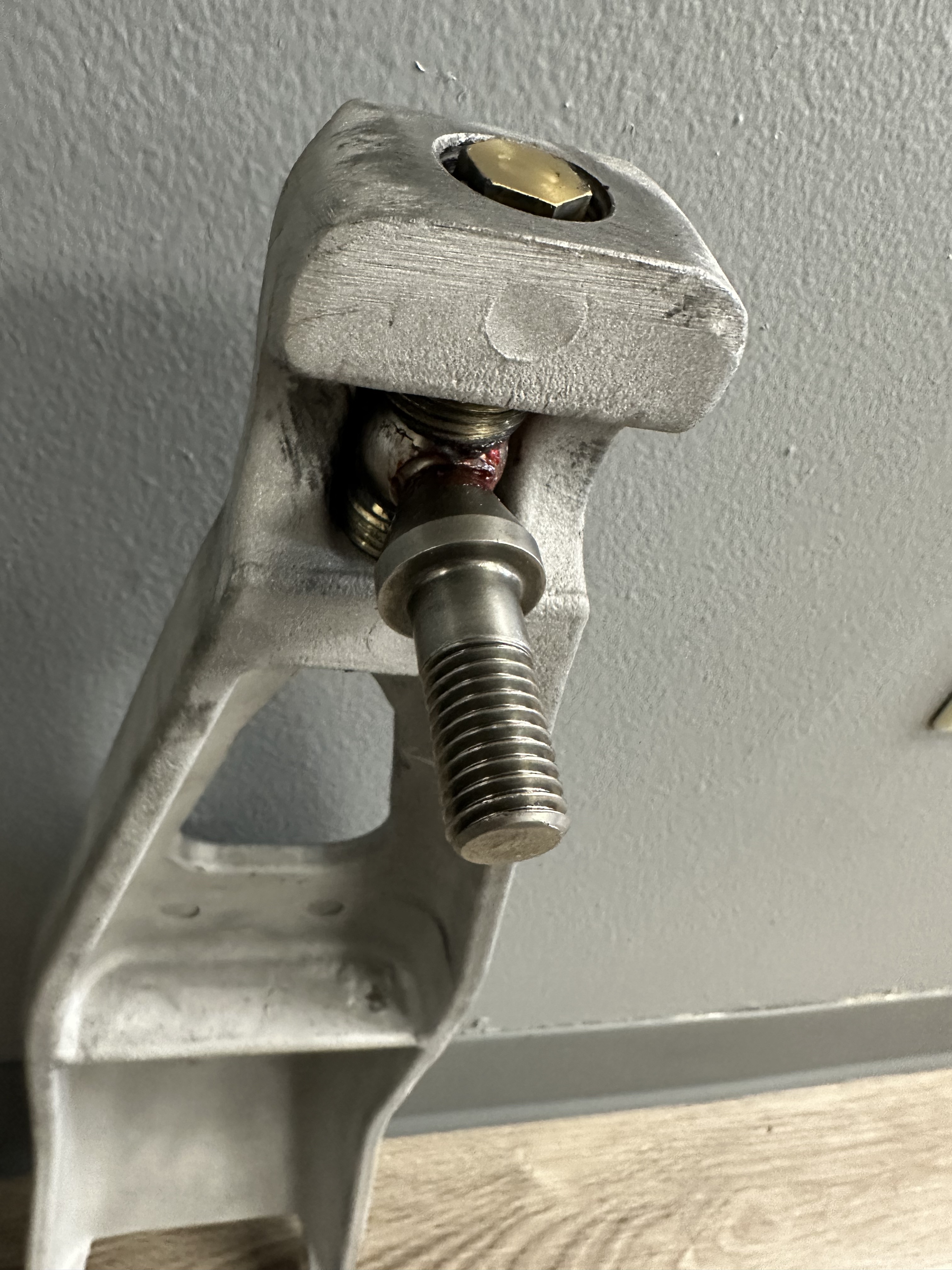 Close-up of rebuilt ball joint end: stainless ball joint stud with brass 3/4-inch hex nut. Threadlocker visible at thread engagement.