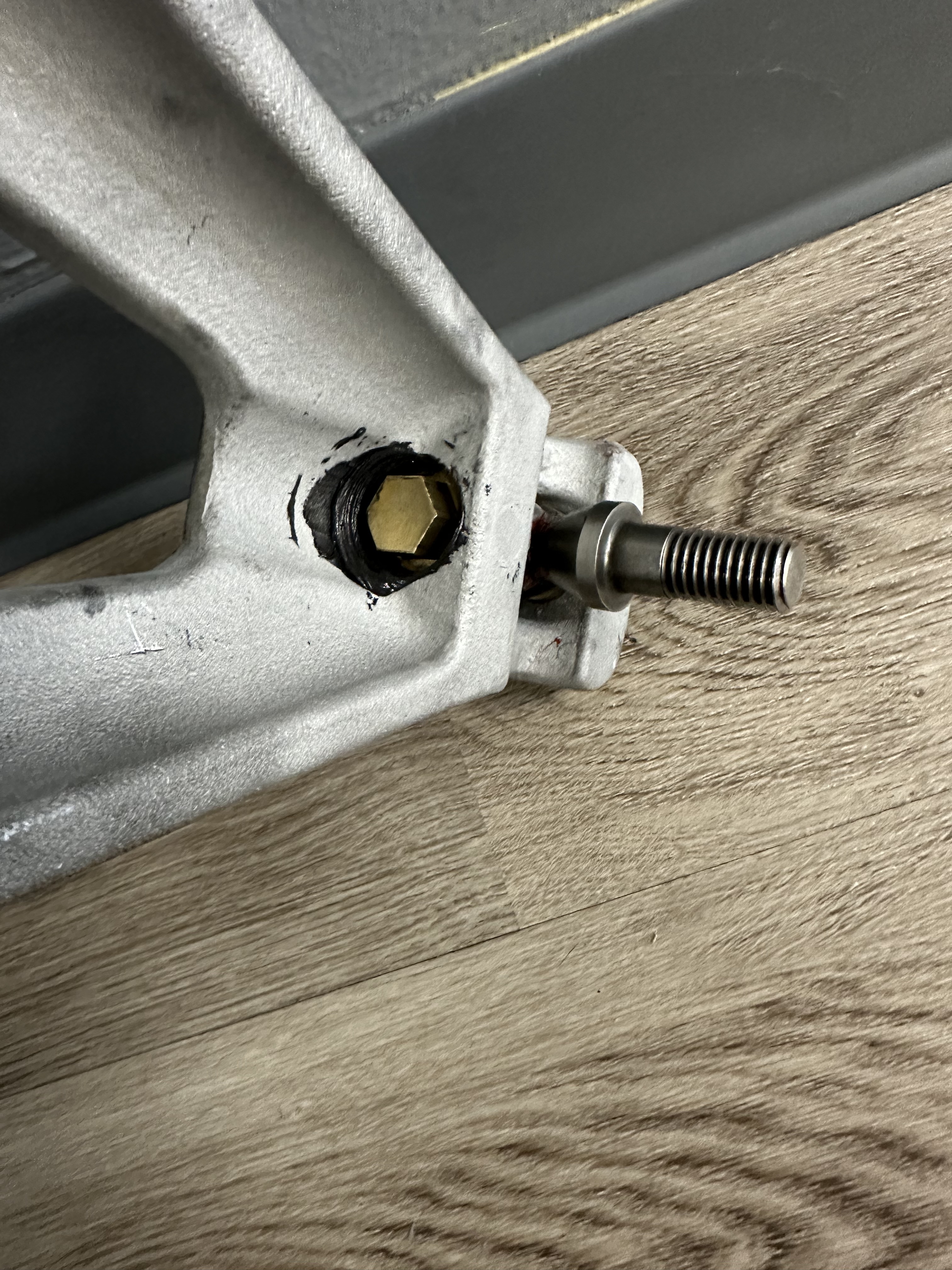 Brass hex-head set screw replacing OEM Allen-key set screw. Black thread sealant applied. 3/4-inch hex head is accessible with a standard wrench.