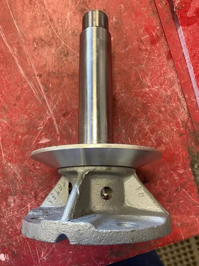 Rebuilt assembly: a stainless-steel shaft with the machined aluminum rain shield press-fit below the housing. A Viton O-ring replaces the OEM felt seal.