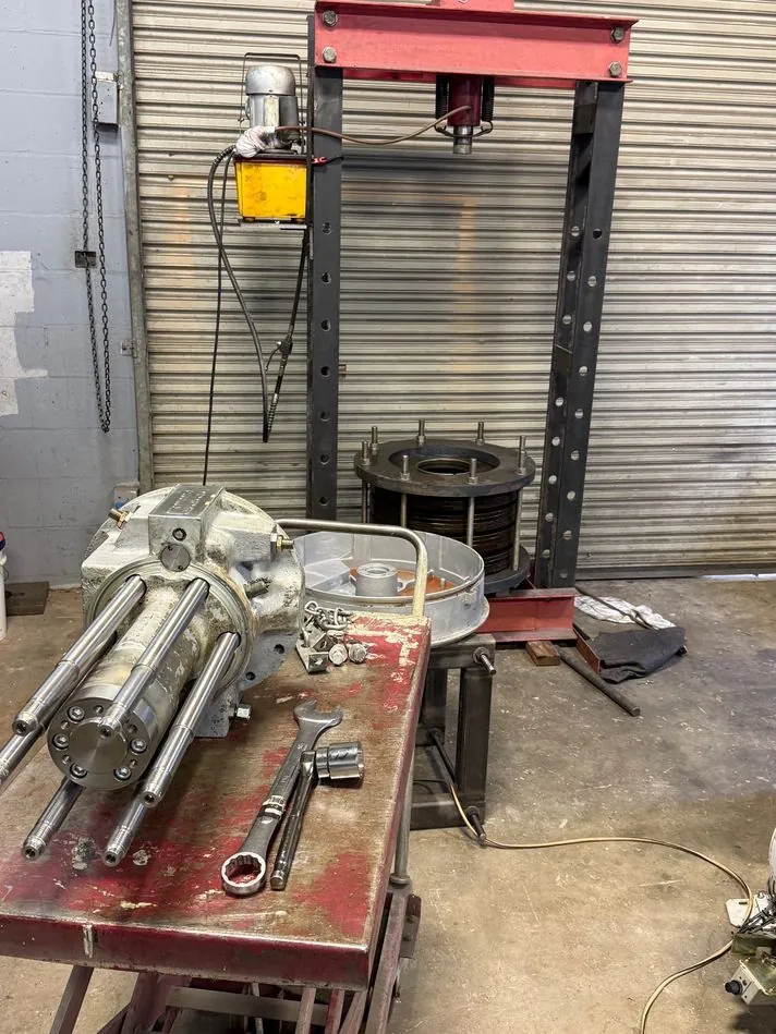 With the disc spring secured, the mechanism is removed, completely disassembled, and every part is inspected for wear.