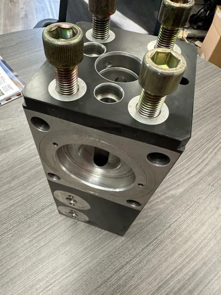 The hydraulic manifold removed from the mechanism for inspection.