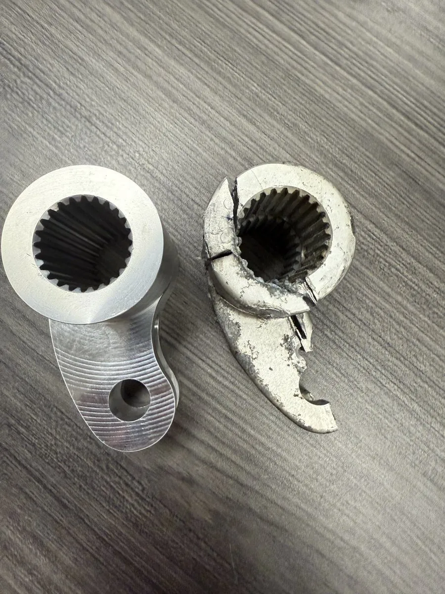 Fractured OEM cast operating-mechanism part from a Siemens SF6 breaker beside the solid-billet replacement machined by Southern Switch & Contacts