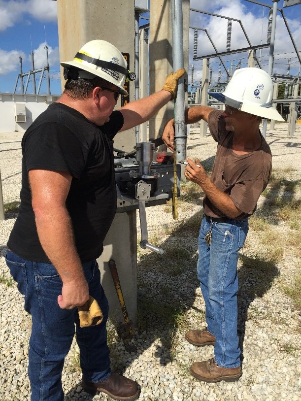 Field crew installing a UGOR on a switch downpipe at a substation