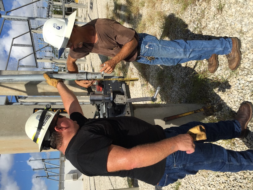 Southern Switch crew members installing a UGOR on a switch downpipe at a substation